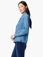 Light blue denim shirt, ruffled collar, long sleeves, button cuffs.