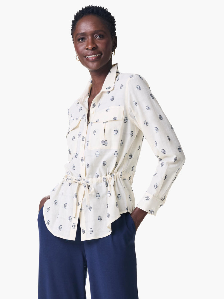 Off-white shirt jacket with navy blue geometric pattern, cinched waist, and long sleeves.