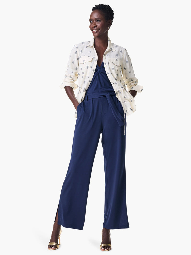 Off-white shirt jacket with navy blue constellation print.  Worn over a navy blue jumpsuit.