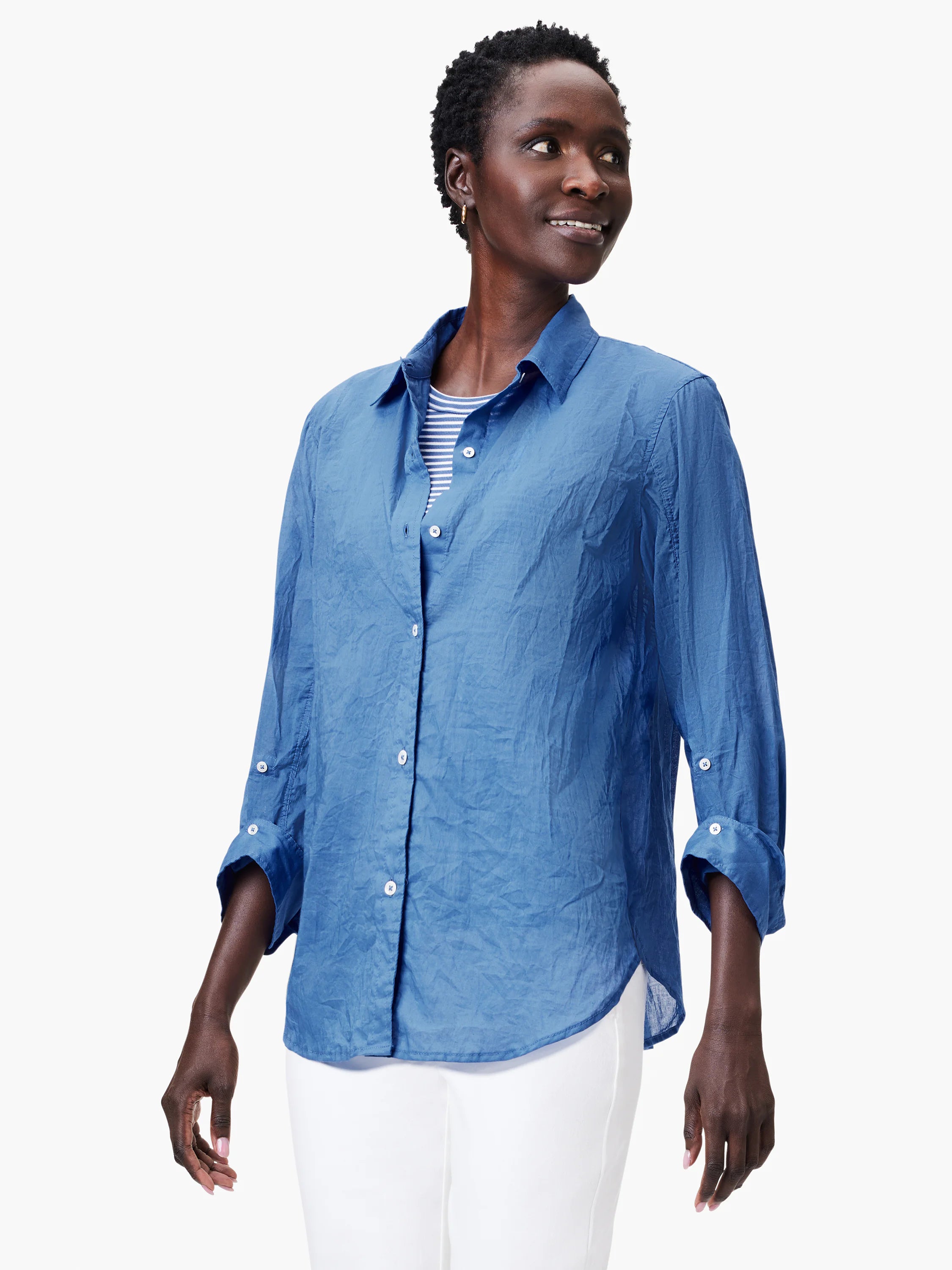 Blue cotton girlfriend shirt with a crinkled texture, button-front, and sleeves rolled to 3/4 length.