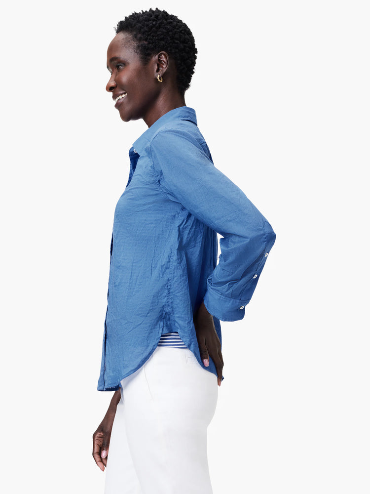 Blue crinkled button-up shirt with collar, white buttons, and rolled sleeves.