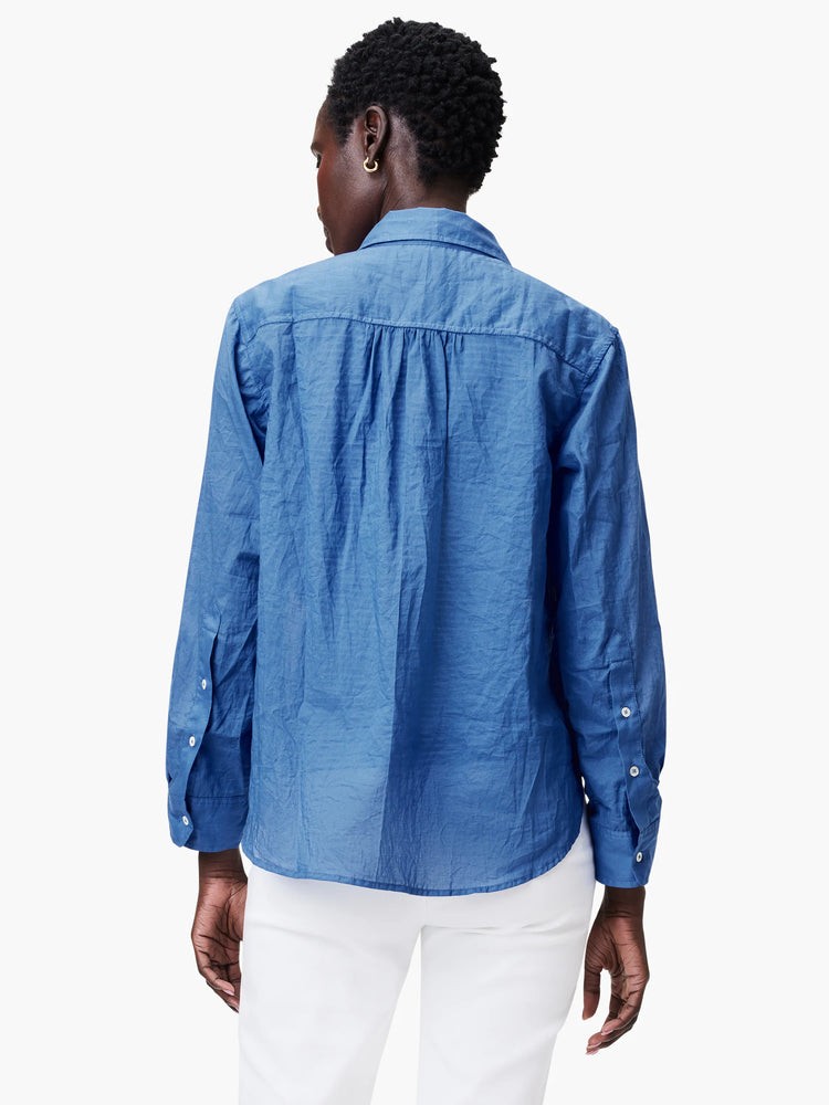 Blue crinkled cotton shirt, back view, with a pleated back yoke and white buttons on the sleeve cuffs.