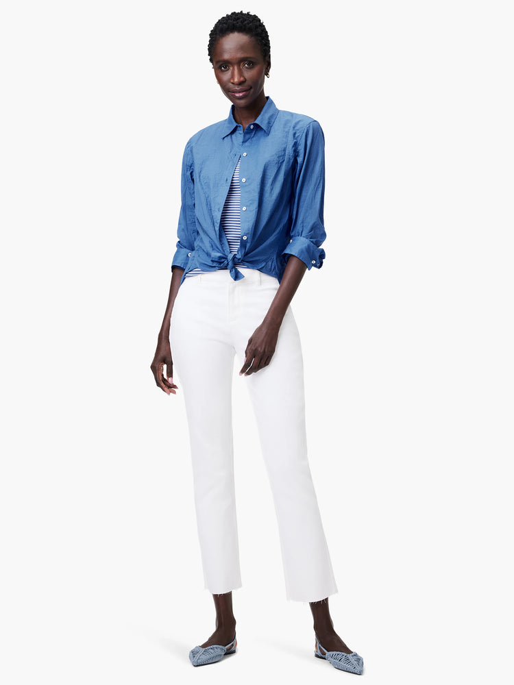 Blue cotton button-down shirt, tied at the waist, with rolled sleeves.