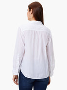 White cotton shirt, back view. Collared, long sleeves with button cuffs. Features a back yoke with gathering & curved hem.