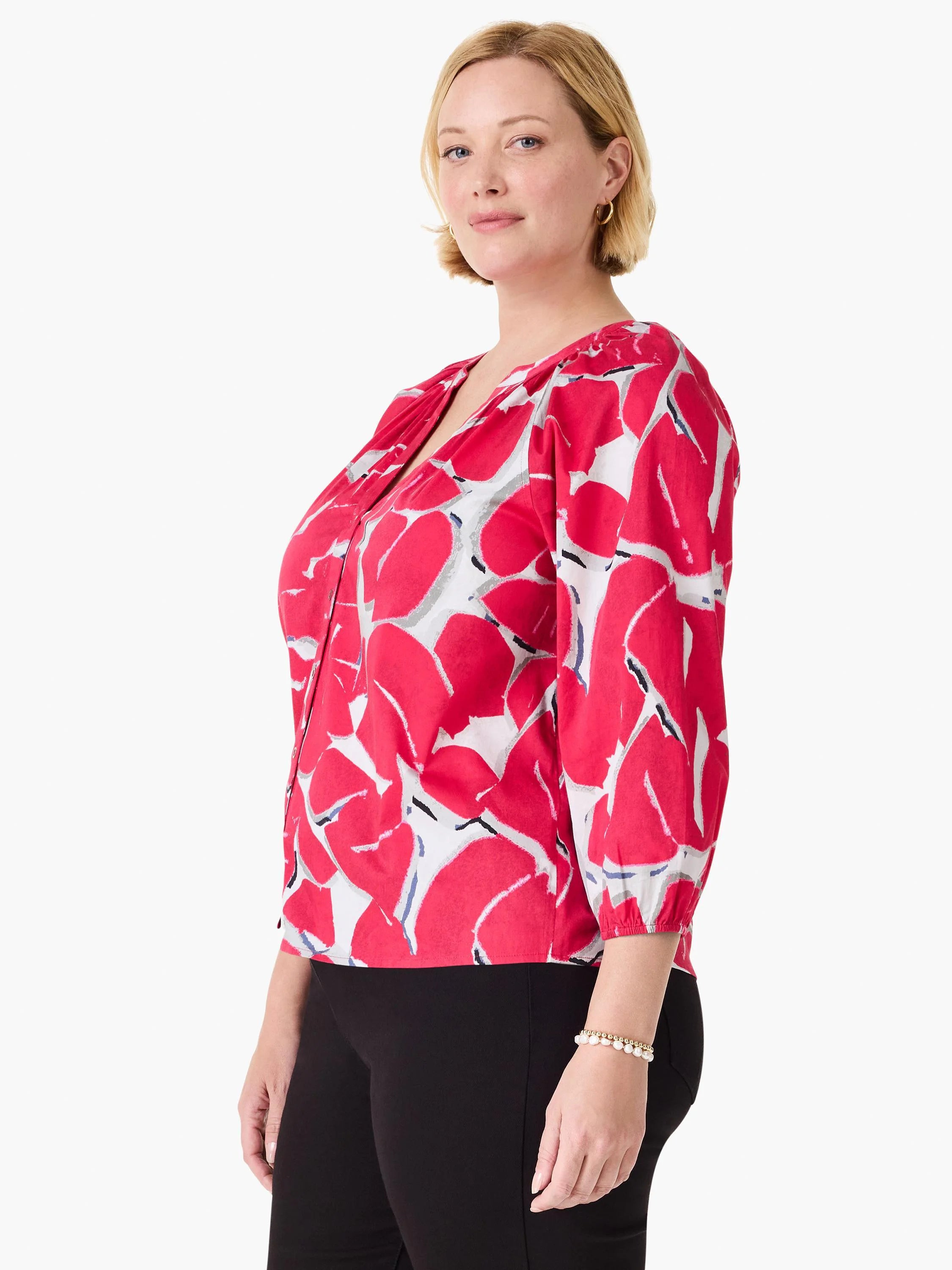 Pink shirt with a white background and gray/black accents.  Three-quarter sleeves, V-neck. Abstract petal print.