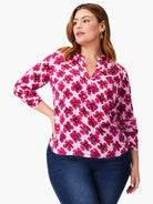 Pink top with a pink and dark pink abstract floral print. Three-quarter sleeves, V-neck.