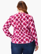 Pink long-sleeve blouse with a pink and red floral print.  The blouse has a fitted waist.