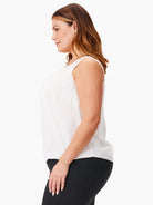 White sleeveless tank with a scoop neck, loose fit, and subtle vertical seams. Sheer, flowy fabric.