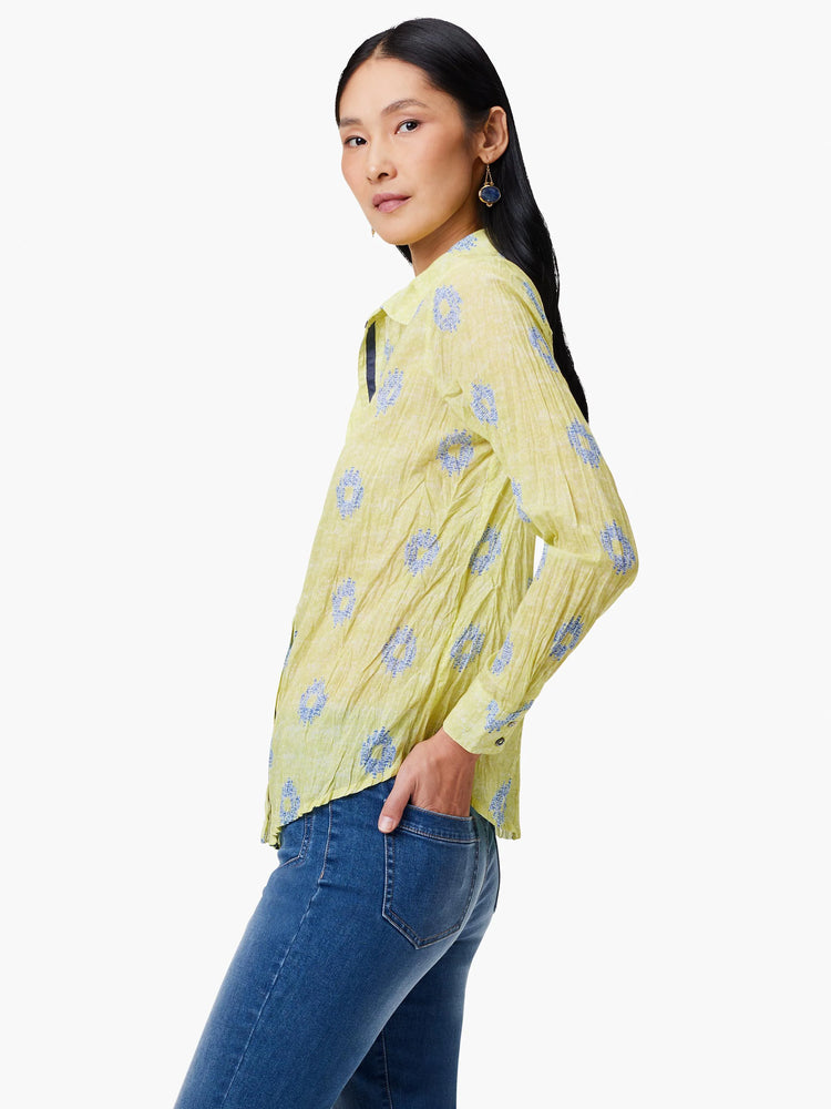 Pale yellow crinkled shirt with a blue floral pattern.  Long sleeves, collared.