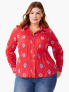 Red button-front shirt with a crinkled texture and small, light blue patterned design. Long sleeves.