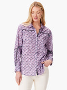 Lavender shirt with dark purple floral print & dark trim accents.  Long sleeves. Button front.