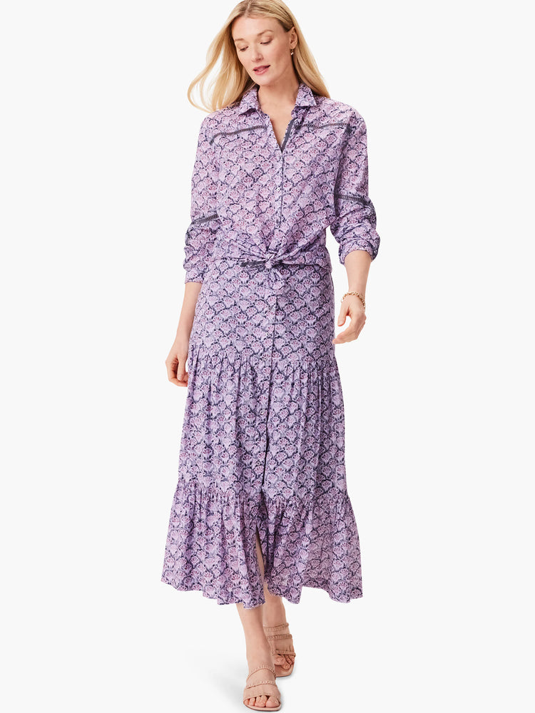 Lilac shirt and midi skirt with a dark purple floral pattern.  Shirt is button-down, tied at waist. Skirt is tiered.