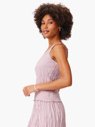 Pale lavender sleeveless tank top on a model. It has a distinct vertical crinkle-crush texture throughout.