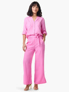 Pink shirt and pants; collared, button-front shirt with pockets; pants have a tie waist and pockets.