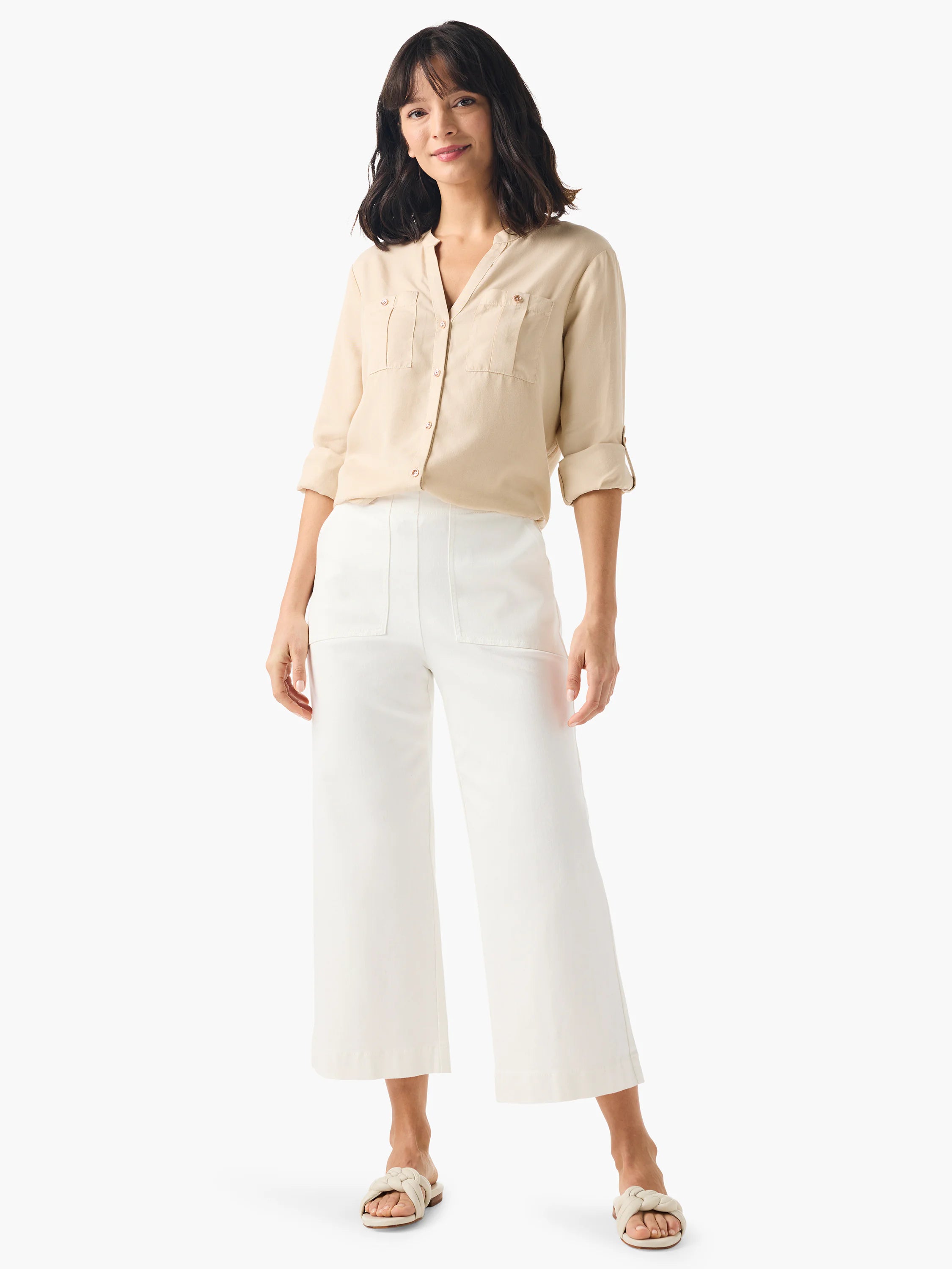 Beige utility shirt with front pockets, button closure.  Model wears it with white wide-leg pants and off-white sandals.