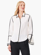 Off-white long-sleeve button-down shirt with black trim along the collar, placket, cuffs, and sleeve seams.  Bell sleeves.