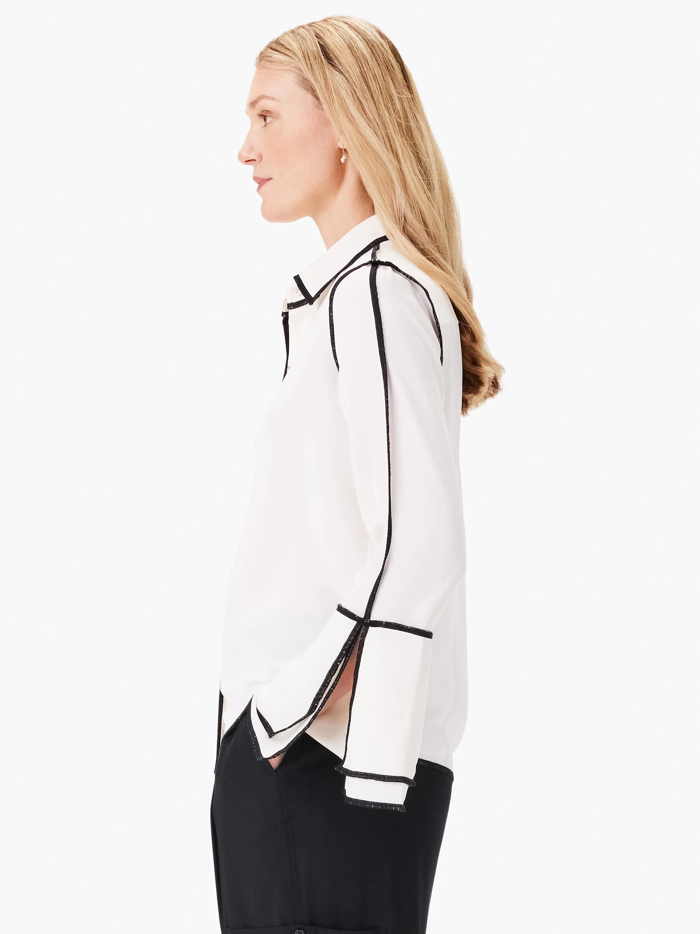 Off-white shirt with black trim along the collar, placket, sleeves, and hem.  Long sleeves.