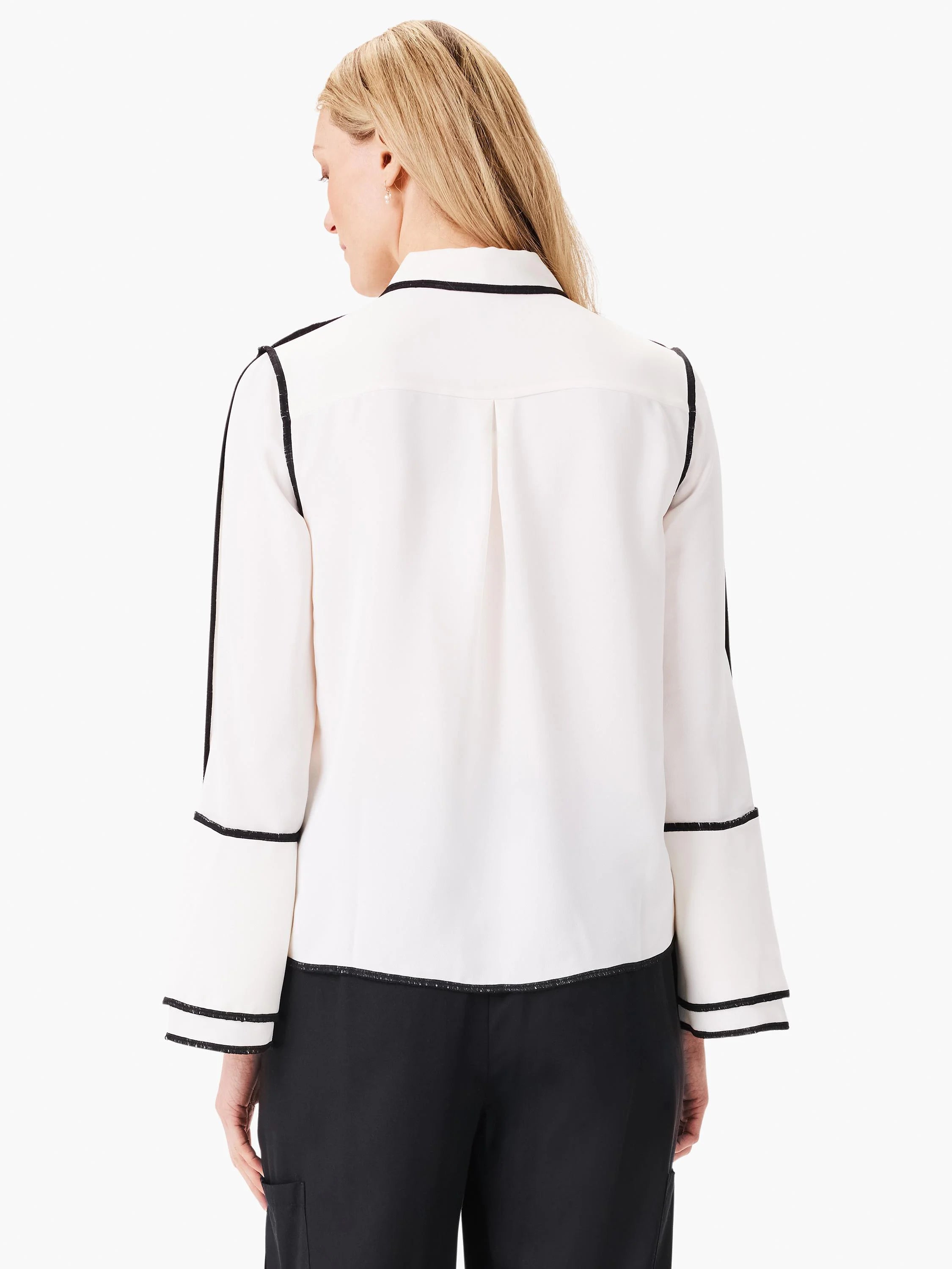 Off-white shirt with black trim at collar, cuffs, and hem; long sleeves, back view.