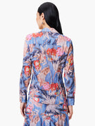 Blue shirt with red, pink & peach abstract floral print.  Long sleeves, collared. Crinkled texture.