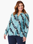 Teal long-sleeve blouse with a dark-navy and beige leaf print, V-neck, and elasticized cuffs.