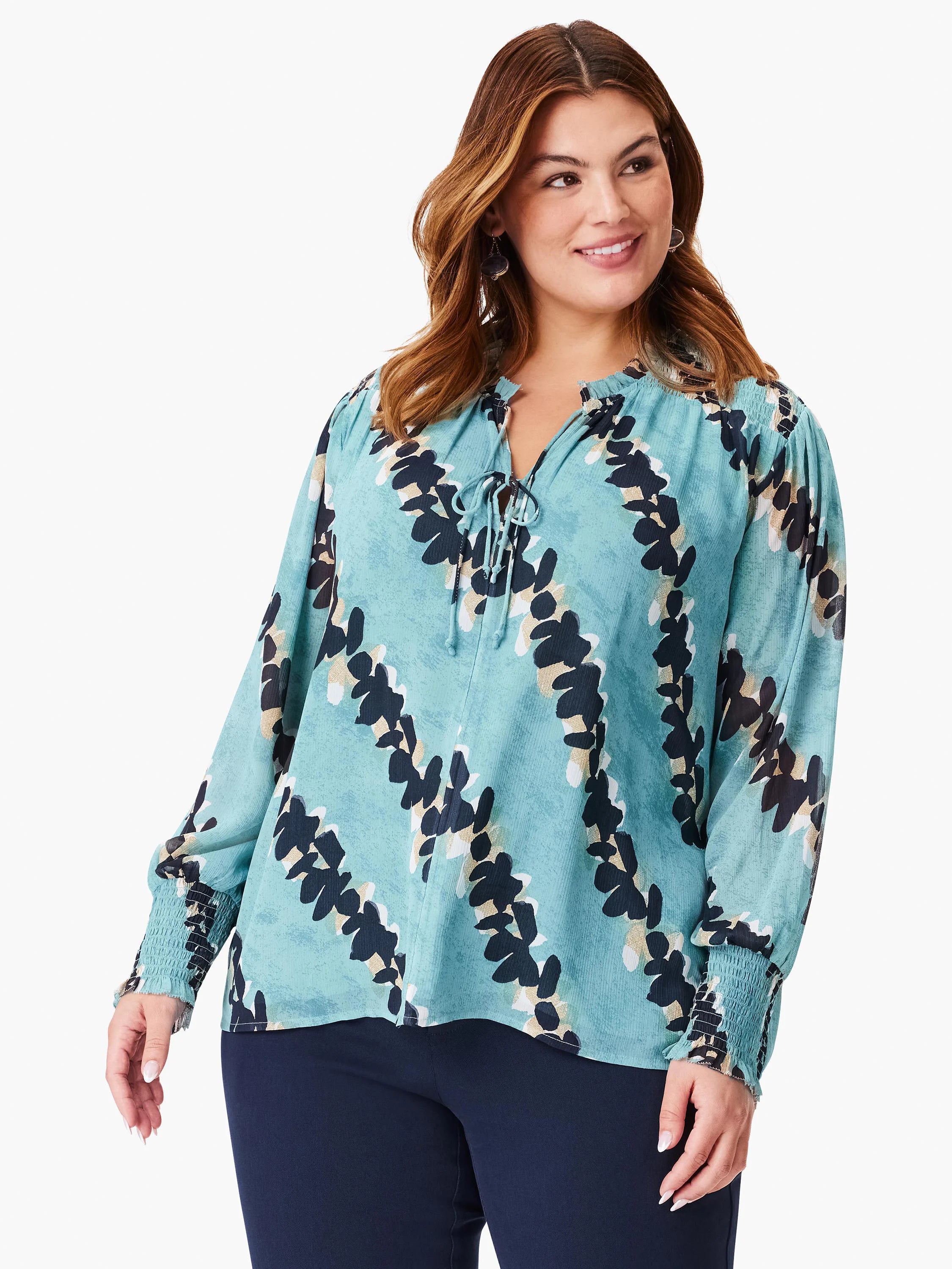 Teal long-sleeve blouse with a dark-navy and beige leaf print, V-neck, and elasticized cuffs.
