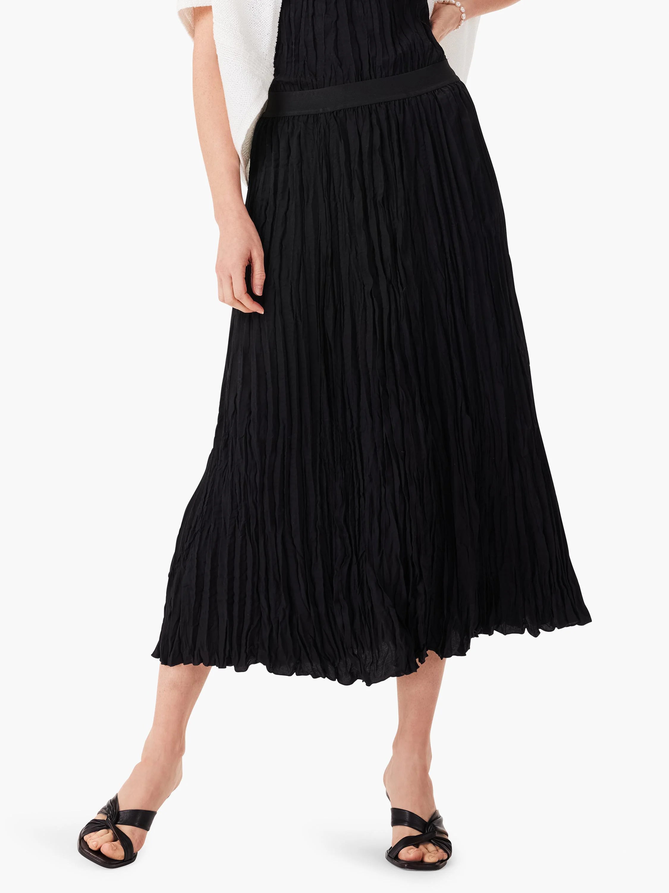 Model wears a black midi skirt featuring a distinct vertical crinkled texture and flat waistband.