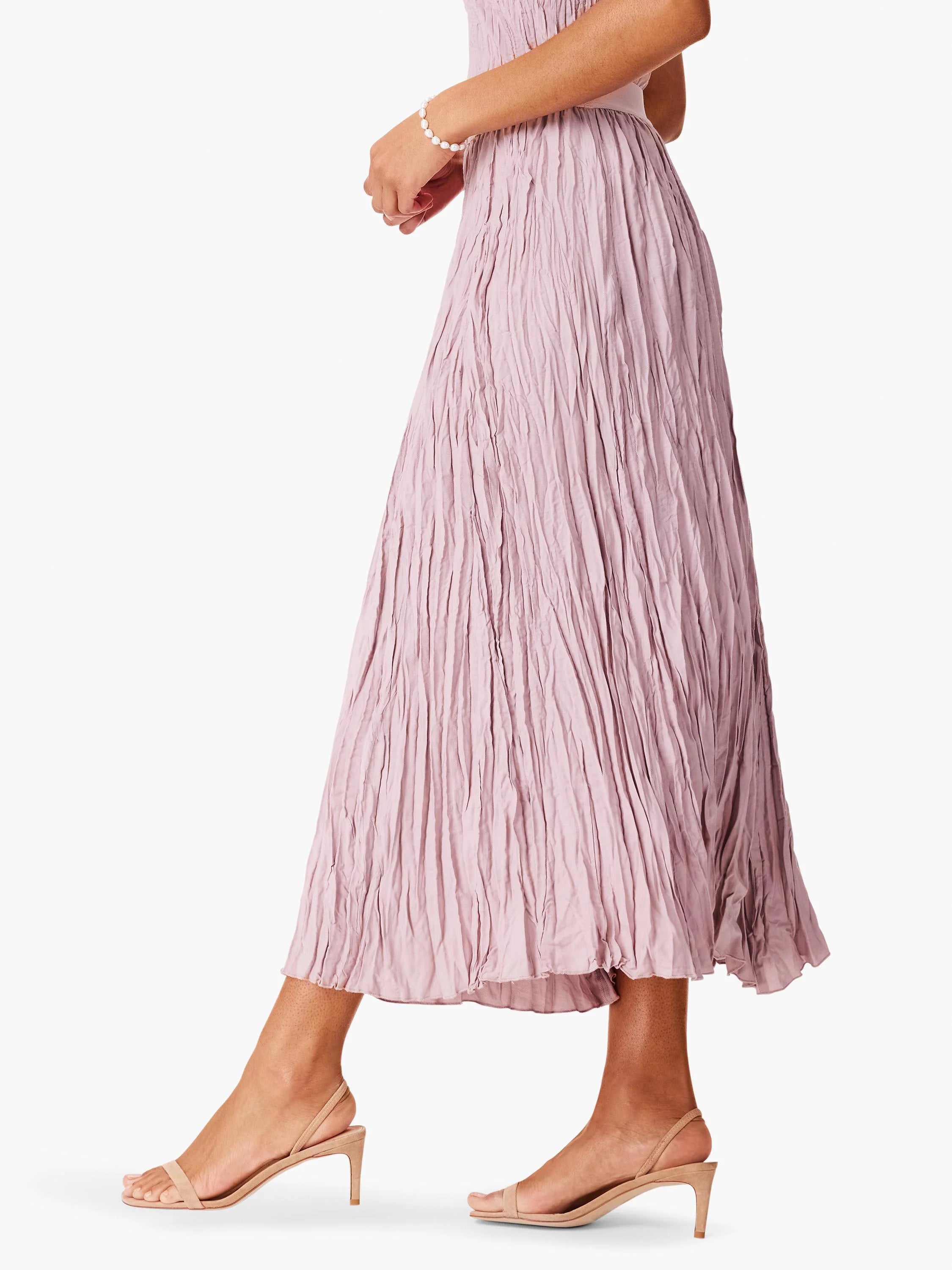 Dusty rose midi skirt with a vertical crushed texture, shown on a standing model.