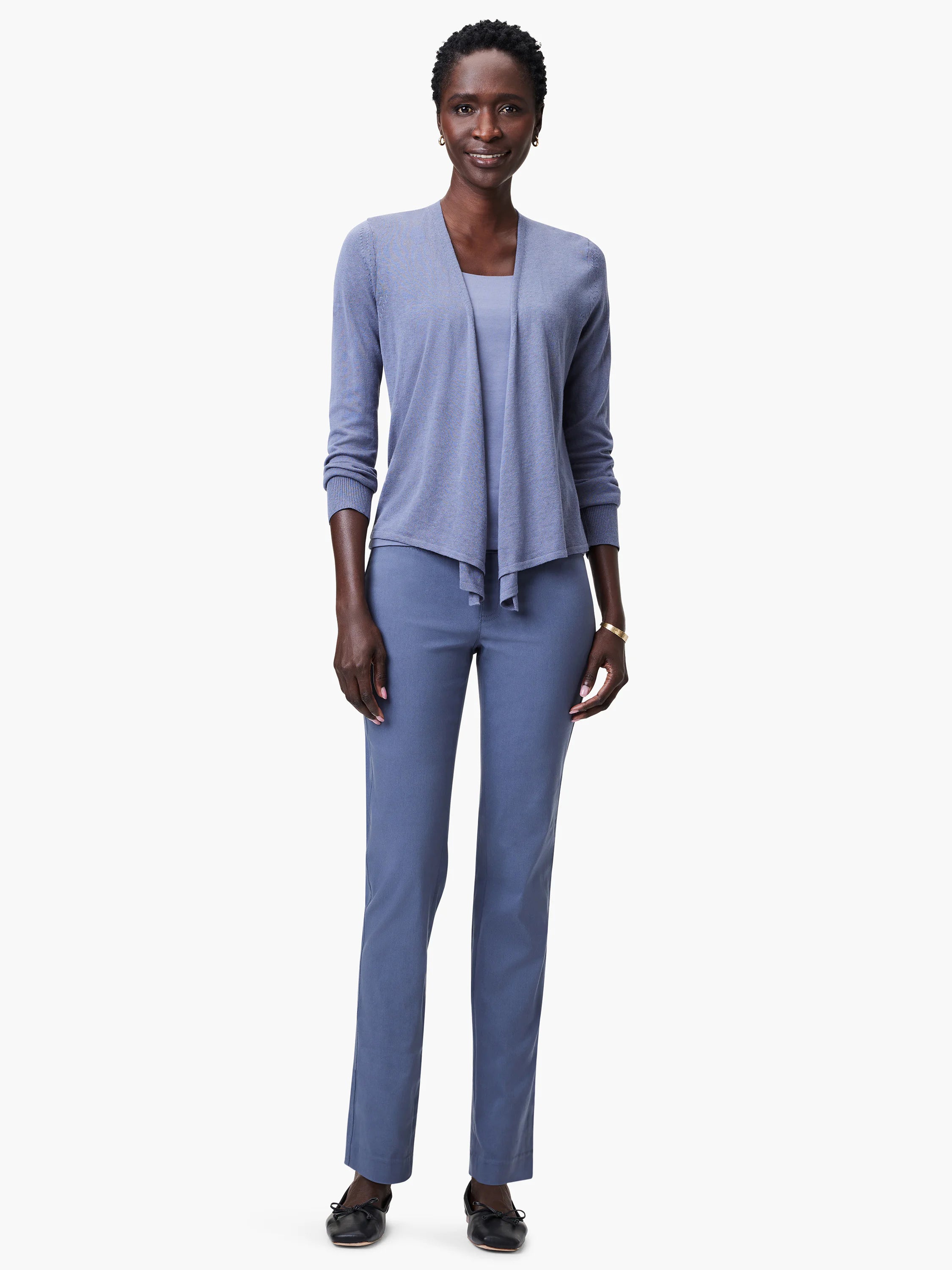 Standing woman models blue straight leg pants with a smooth, tailored fit.