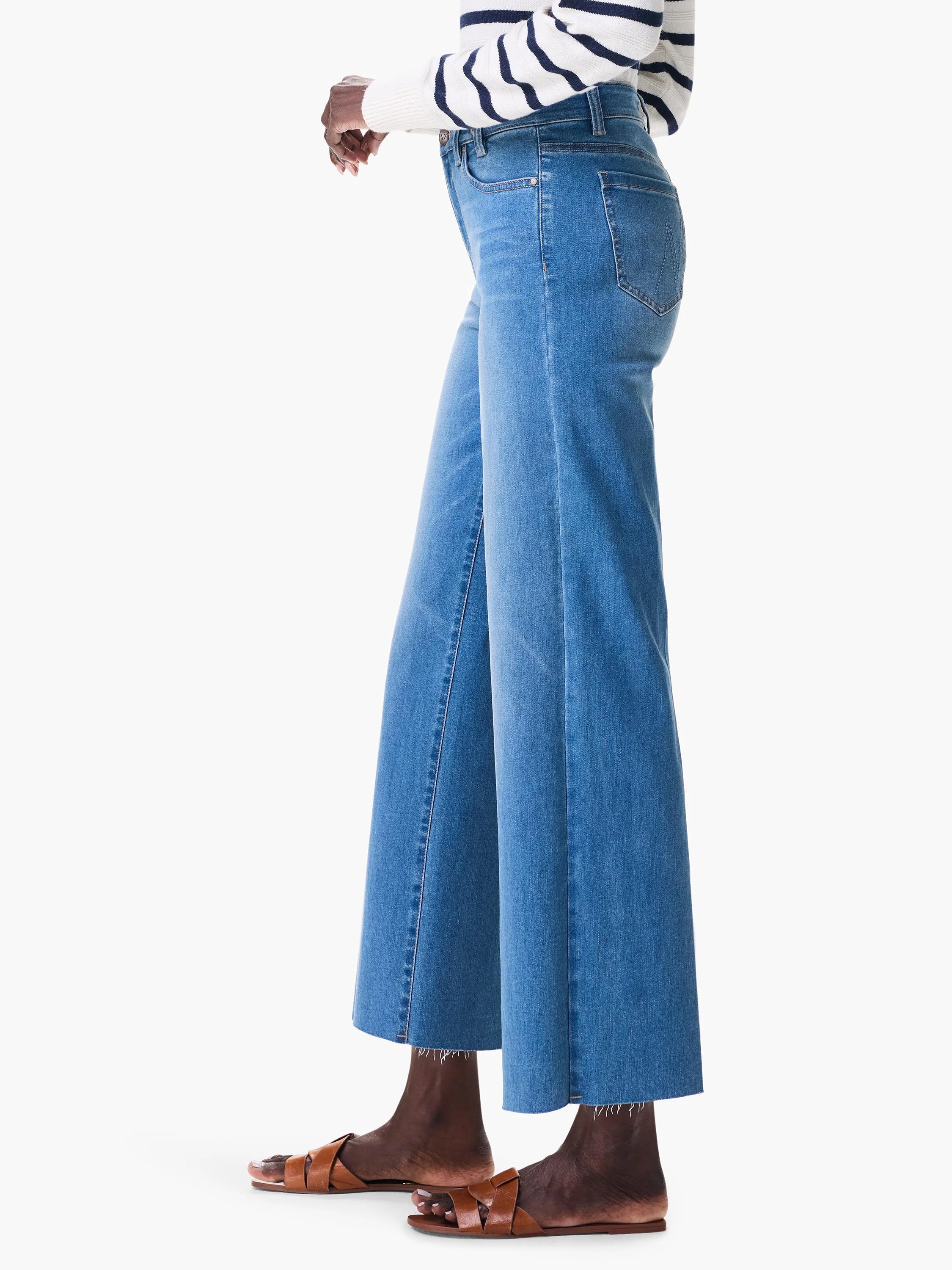 Cropped, medium blue wide-leg jeans feature a raw, frayed hem.