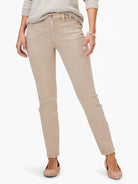 Tan mid-rise straight jeans featuring visible front utility-style pockets with contrast stitching and a button closure.