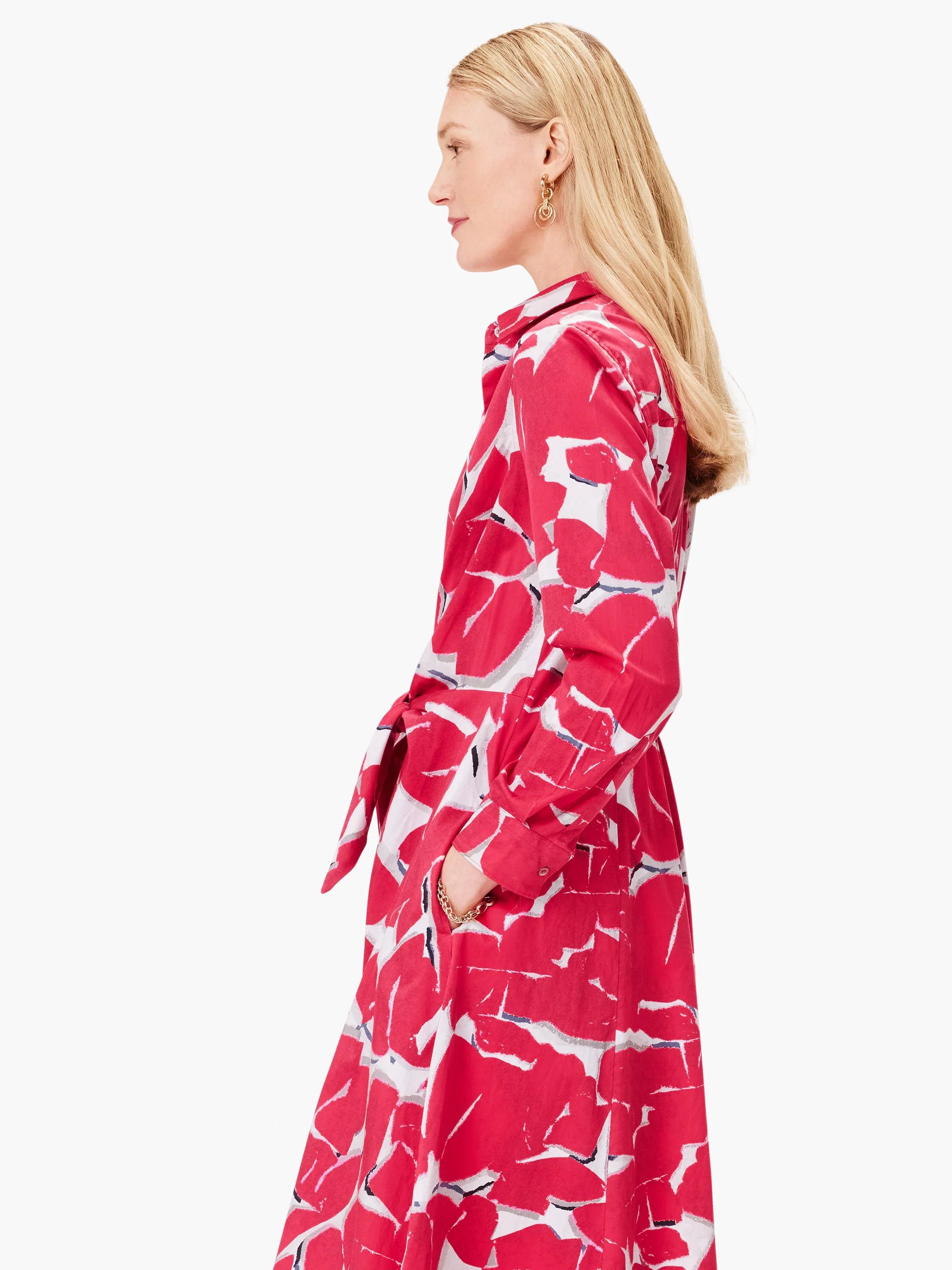 Pink midi shirt dress with an abstract print in shades of pink, white, and gray.  Features a collared neckline and a tie...
