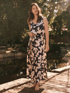 Navy blue maxi dress with beige floral print, sleeveless, V-neck, belted waist.