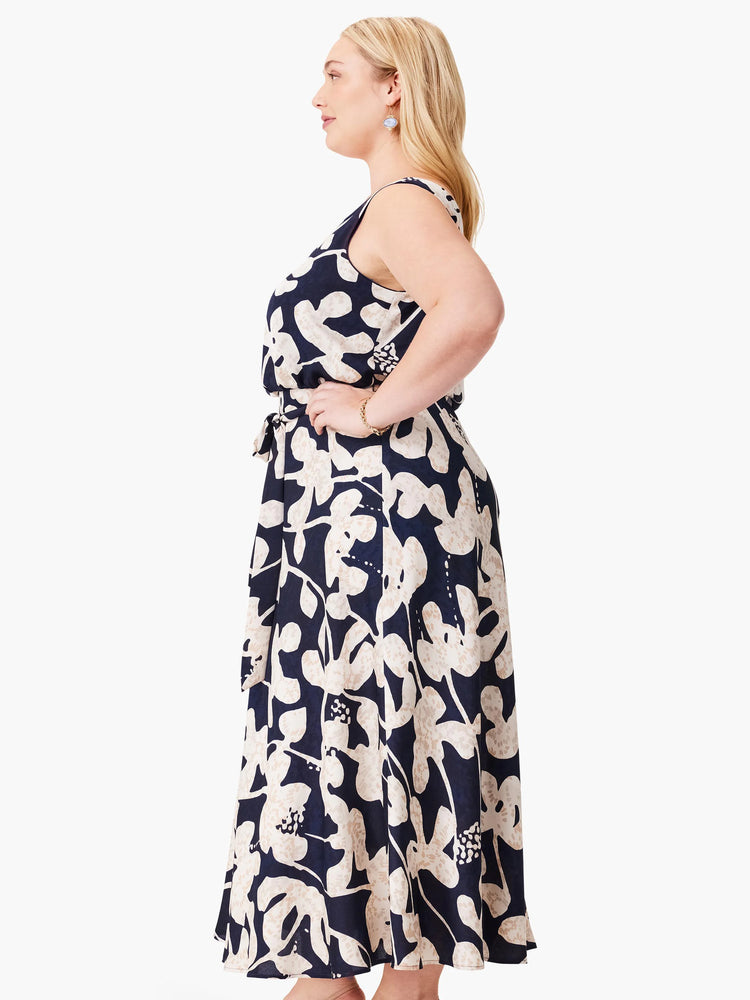 Navy midi dress with beige floral print, sleeveless, belted waist.