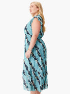 Teal midi dress with a ruffled neckline and hem. Features a dark-navy and cream leaf print.  Sleeveless.