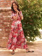 Maxi dress with red, pink, and beige abstract floral print.  Tiered skirt and short sleeves.