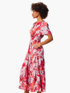 Mid-length tiered dress, pink and red abstract print, short sleeves, V-neck.