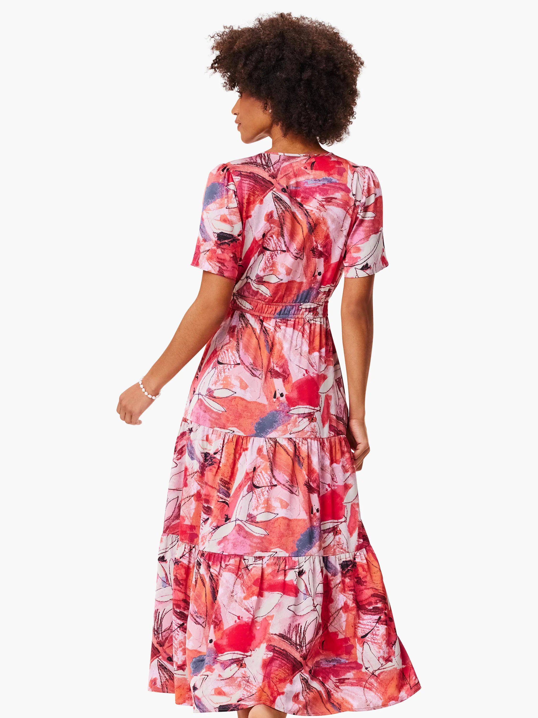 Pink tiered maxi dress with abstract leaf print in shades of pink, red, and gray.  Short sleeves.