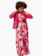Pink abstract print maxi dress layered under a hot pink textured jacket.