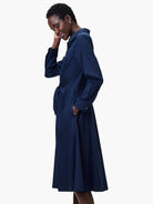 Navy blue, knee-length shirt dress with long sleeves, a belted waist, and pockets.