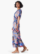 Blue maxi dress with pink, coral, and beige abstract floral print.  Short sleeves, tiered skirt.