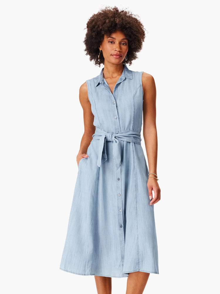 Light blue denim shirtdress, sleeveless, collared, belted at waist, A-line skirt, button front, pockets.