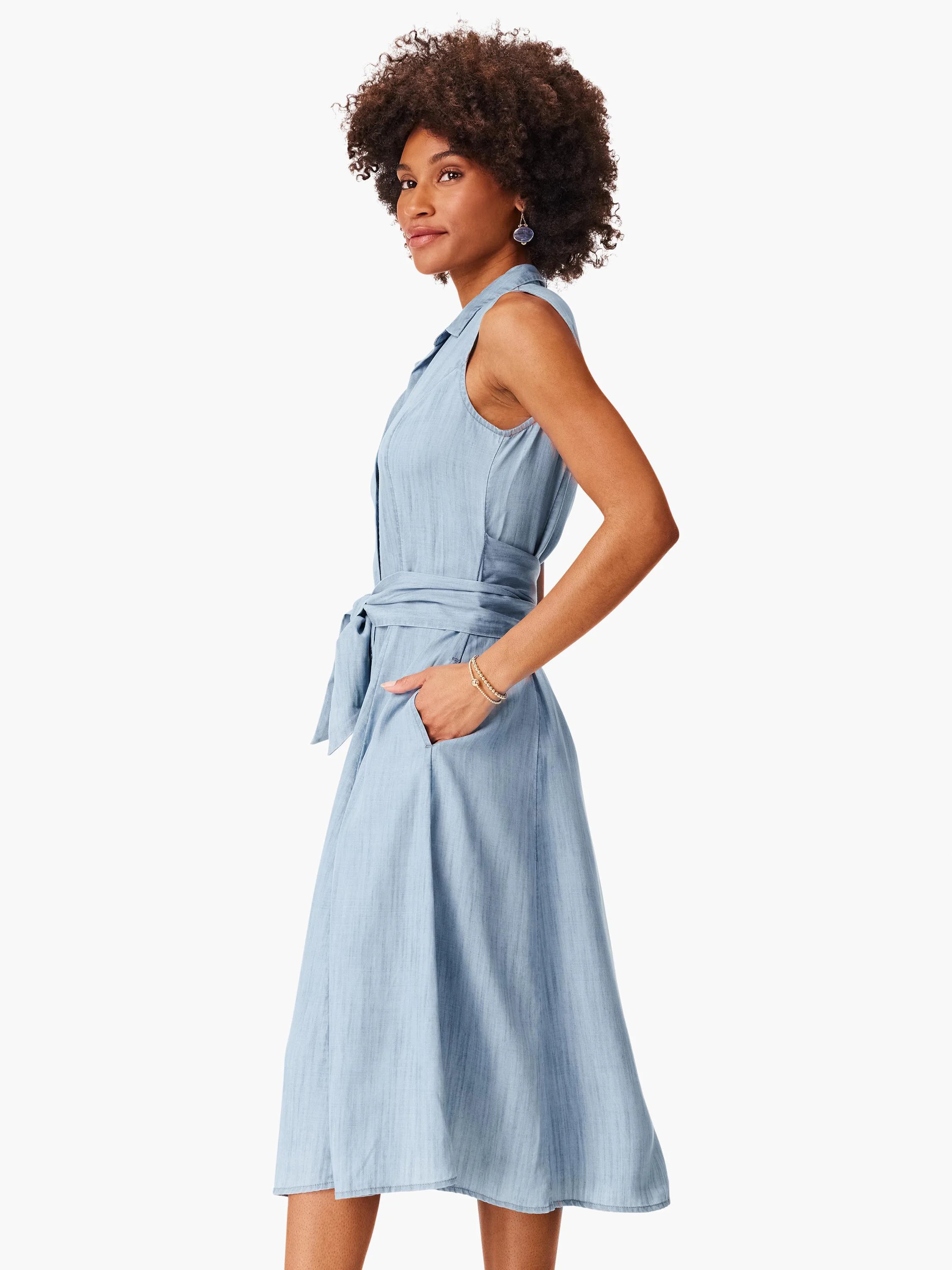 Light blue denim shirtdress; sleeveless, collared, belted at waist, A-line skirt, pockets.