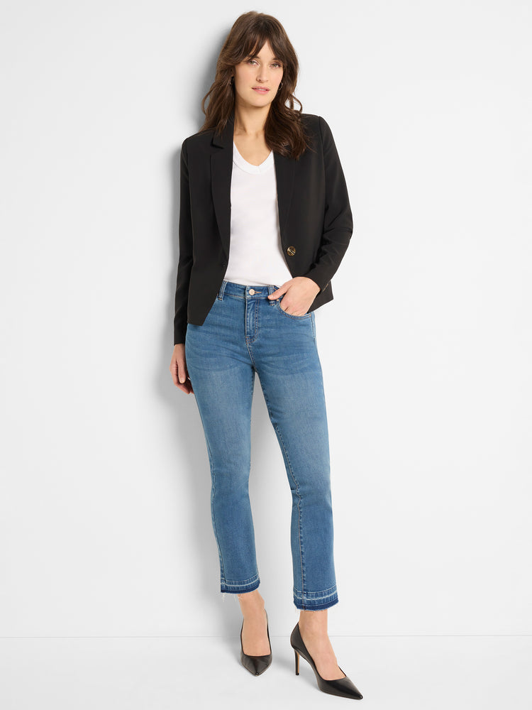 Medium blue wash high-waisted jeans with a slim fit and frayed cropped hem are worn with a black blazer.