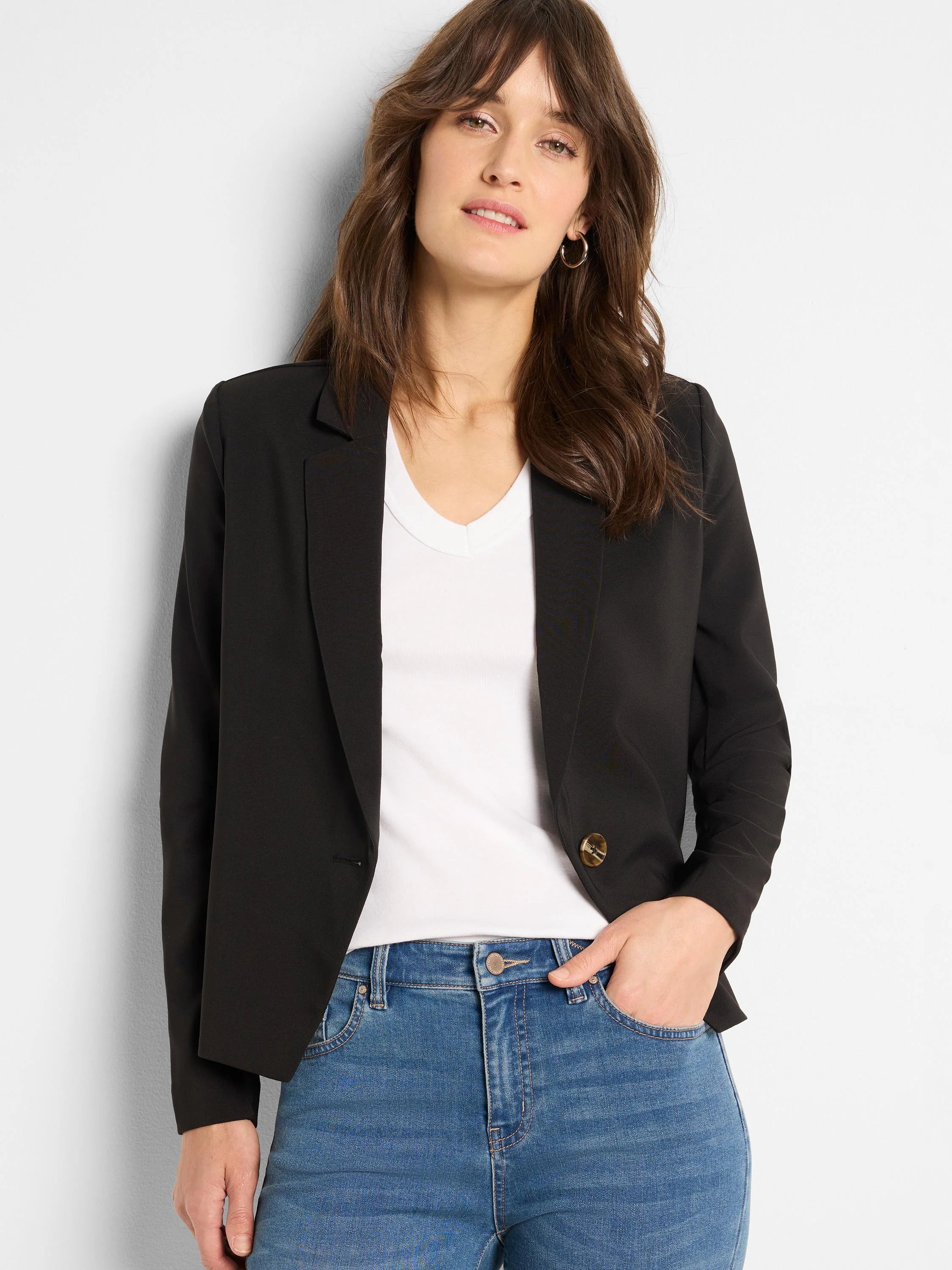 Black, single-breasted blazer with lapels and a visible tan button, shown open over a white shirt.