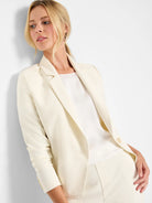 Cream blazer with smooth fabric, notched lapels, single button closure. Worn with matching cream pants.