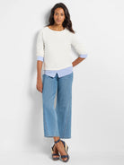 Cream long-sleeve boat-neck top, designed to look layered over a blue and white striped shirt with visible cuffs and hem.