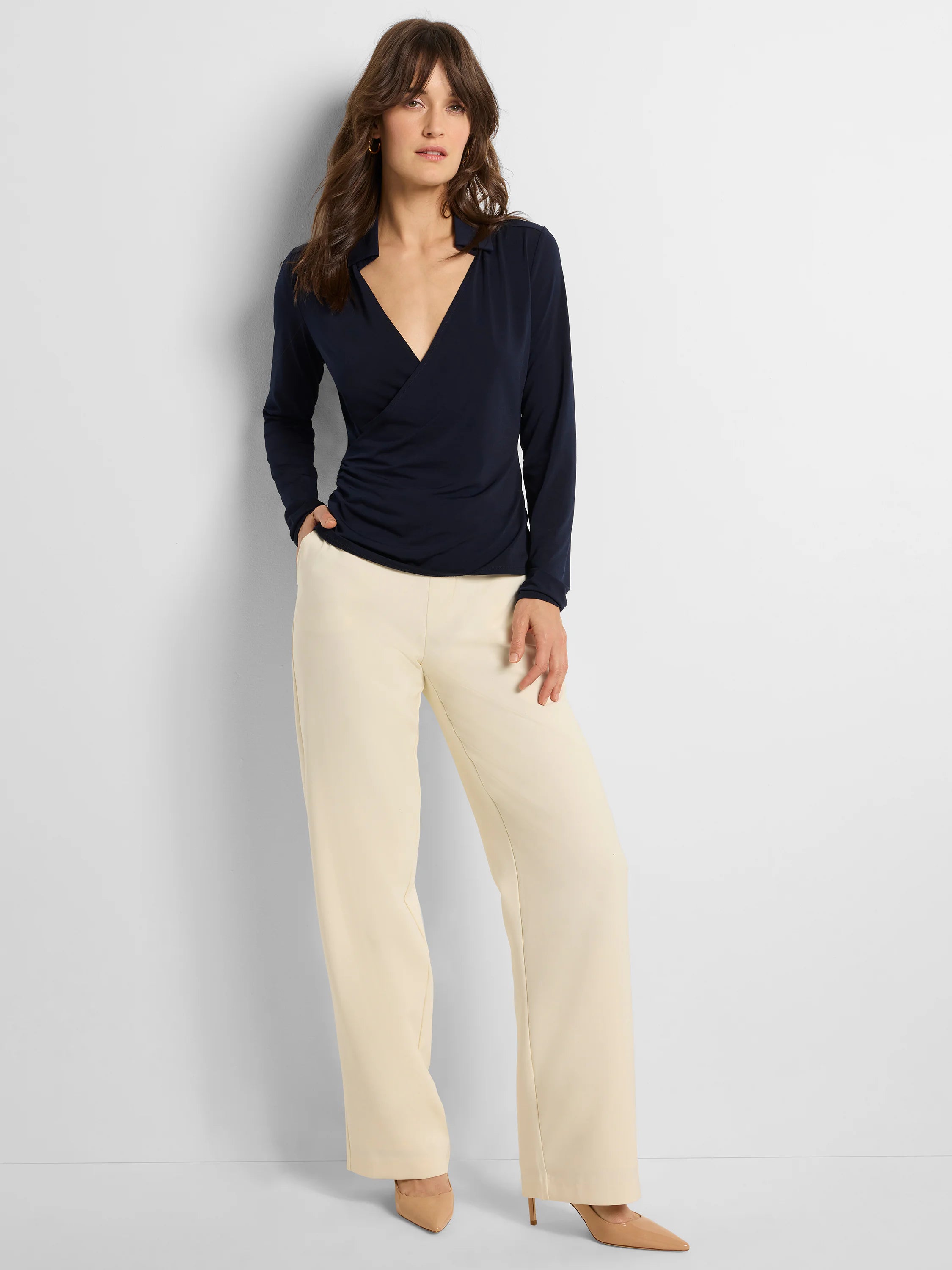 Navy collared knit wrap top with a deep V-neck, long sleeves, and gathered detail at the side waist.