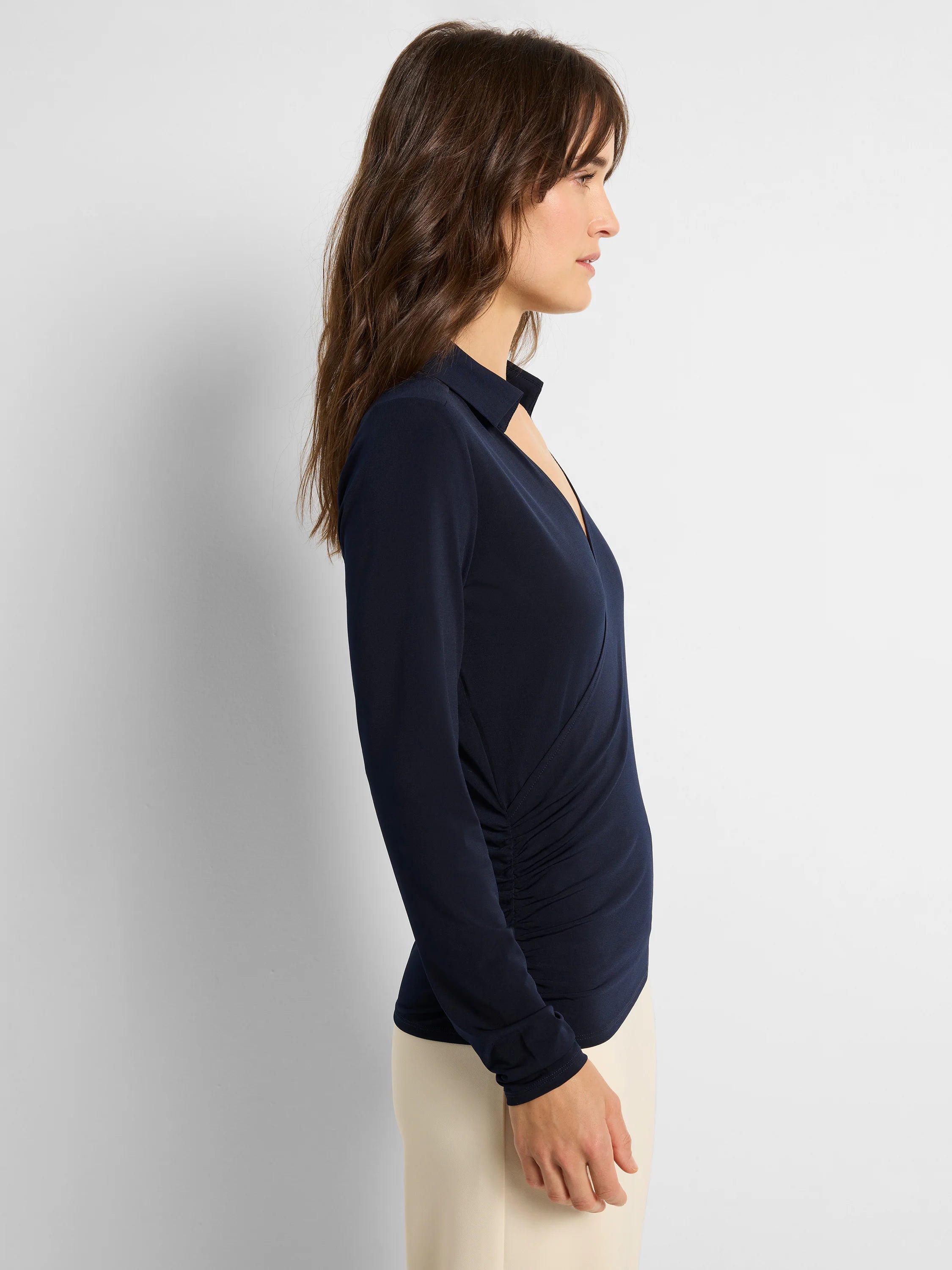 Navy blue collared knit wrap top with a deep V-neck and gathered side detail.