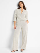 Off-white knit top with dark, repeating V-pattern, V-neck, and 3/4 sleeves.