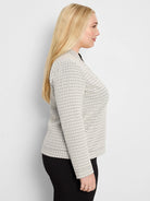 Light cream knit top with a black, repeating chevron pattern creating a subtle swirl.